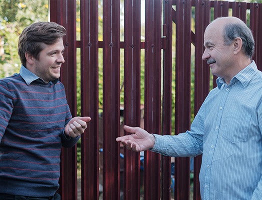 neighbours speaking next to fence