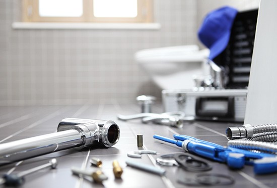 plumbing tools and components laid out on floor