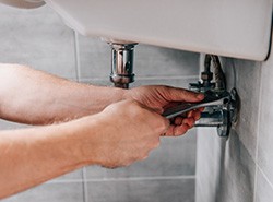 plumber working under sink