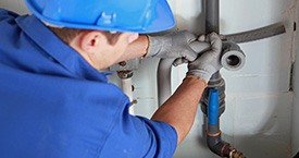 mechanic replacing a burst pipe