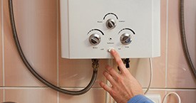 hand pressing  dial on a boiler