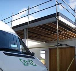 Glass fibre specialists flat roofing systems logo on van bonnet by scaffolding.