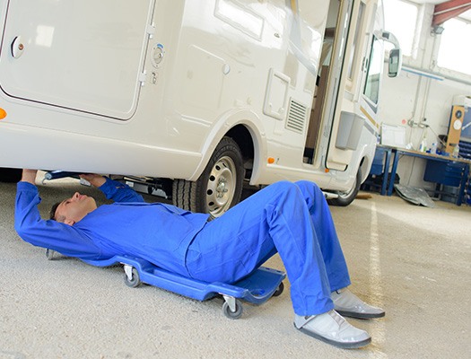 mechanic working under a motorhome