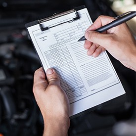 man with checklist over a car