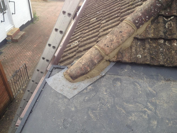 EPDM flat roof finished against a tiled roof slope