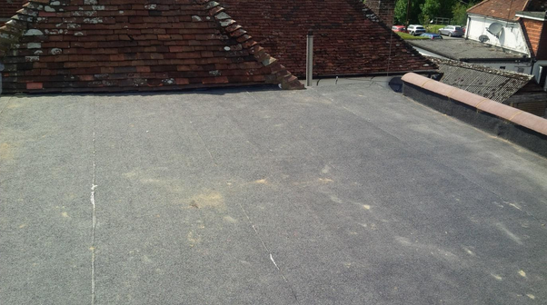 Dark grey flat roof beside a tiled roof
