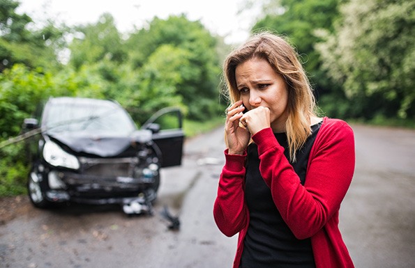 woman calling emergency services after car accident